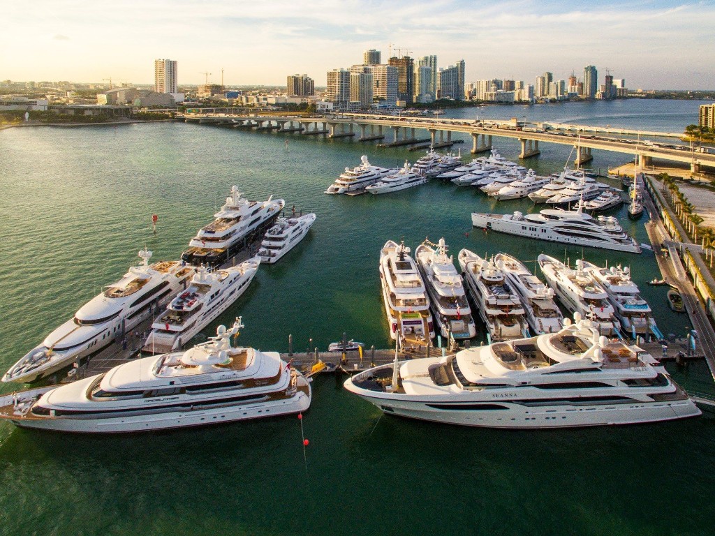 Luxury yachts docked at a Miami-Dade marina with skyline
